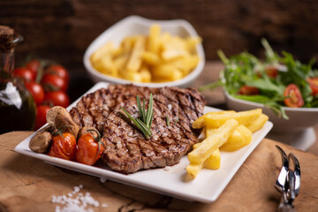 Sliced grilled medium rare beef steak served with fries