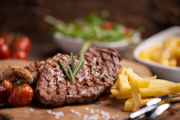 Sliced grilled medium rare beef steak served with fries