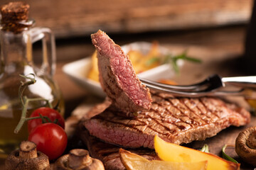 Sliced grilled medium rare beef steak served with fries