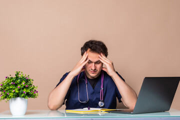 Overworked young doctor sitting in his office