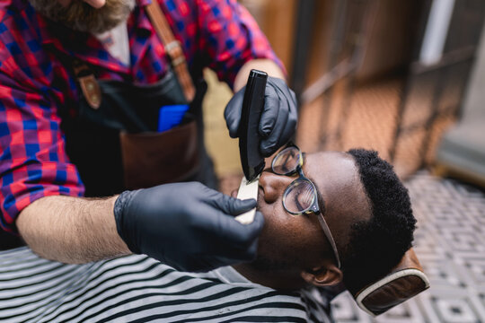 Young African man visiting barber shop.