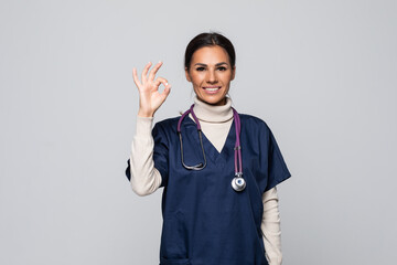 Happy smiling female doctor with okay gesture on white background