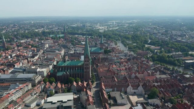Aerial panoramic footage of old town lined with river. Landmarks in UNESCO world heritage site. Luebeck, Schleswig-Holstein, Germany