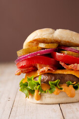 Beef burger with cheese and bacon on wooden table