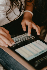 Woman typing on a tablet