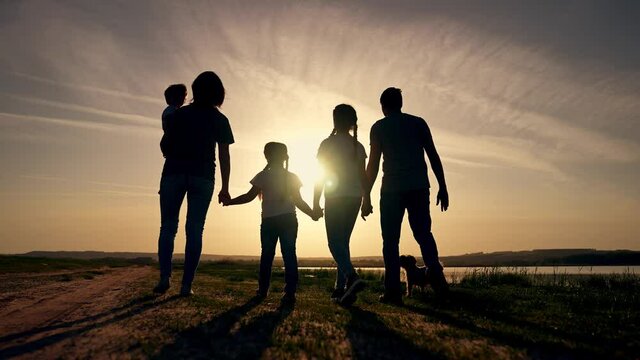 Happy family. Hiking in park. Happy cute family walking in nature park by lake. Parents with children walking. Family picnic by lake. Hiking in natural park. Children walk with their parents.