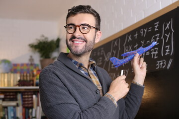 Teacher holding a toy airplane in classroom