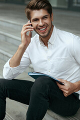 Businessman sit on stairs and using mobile phone