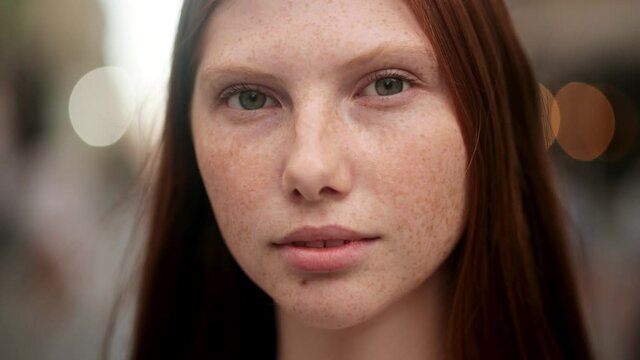 Young beautiful red-haired woman opening her Beautiful blue Eyes. Close up footage of beautiful Caucasian foxy girl. Attractive girl with nice Freckles on her Beautiful Face