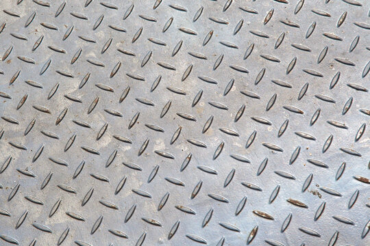 Gray embossed metal plate with a repeating pattern