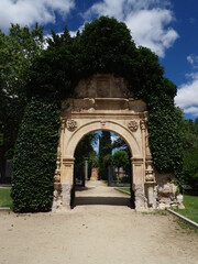 Fototapeta na wymiar arco de piedra entrada a los jardines del castillo