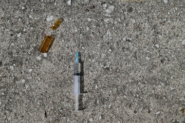 ampoule with injection and syringe on gray stone background