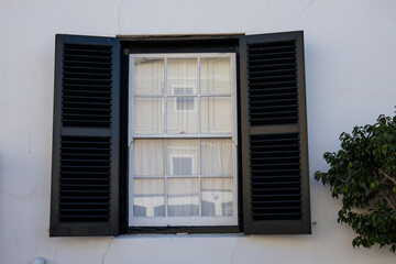 A vintage window with green shutters