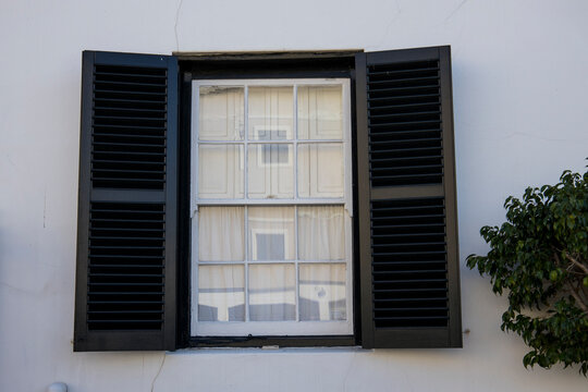 A Vintage Window With Green Shutters