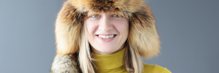 Portrait of young smiling woman in winter fur hat
