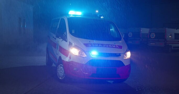 Ambulance car with blue and red lights at street in dark evning. Paramedical vehicle at city outdoor at night shift.