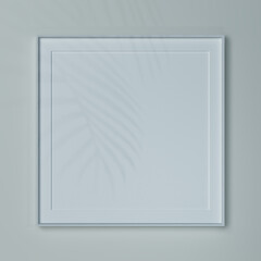 Empty square frame on a wall in natural light. Mockup of a picture or poster in white wooden frame.