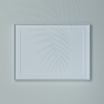 Empty gorizontal frame on a wall in natural light. Mockup of a picture or poster A2 in white wooden frame.