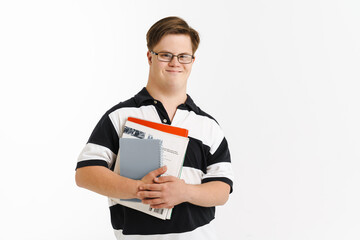 Young man with down syndrome smiling while holding exercise books