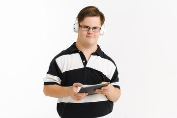 Young man with down syndrome using tablet computer and headphones