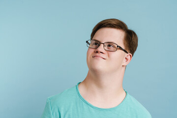 Young man with down syndrome smiling and looking aside