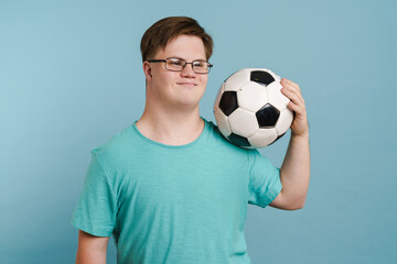 Young man with down syndrome smiling and holding football