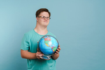 Young man with down syndrome smiling and holding globe