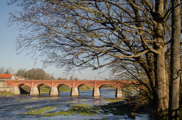 Long brick bridge in sunny spring day, Kuldiga, Latvia. 