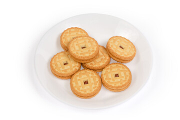 Round sandwich cookies with cherry jam filling on white dish