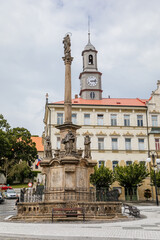 Benesov nad Ploucnici, North Bohemia, Czech Republic, 26 June 2021: Marian Column with baroque statues at main town square, old saxoxy renaissance Morzinov Castle and Town Hall at summer sunny day