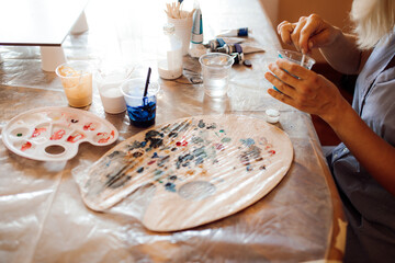 artist working on creating picture in her art studio. Interior painting. Hobbies and crafts. Happiness and creativity.