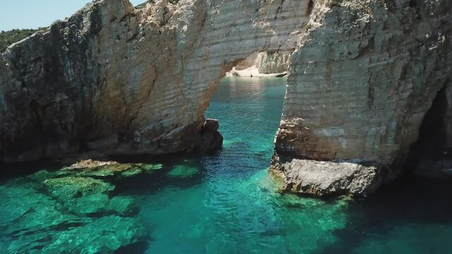 4K Aerial footage of beautiful arch in white rock and a small boat near Keri Caves, Zakynthos Island, Greece. Turquoise water.