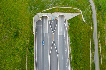 Top view on the tunnel entrance of highway covered with green grass