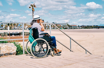 Handicapped female traveler taking photos of beach
