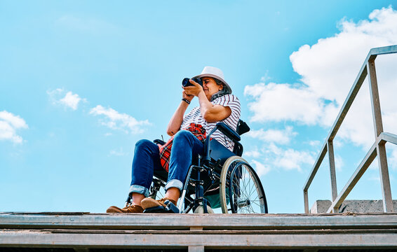 Handicapped female traveler taking photos on street