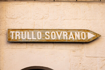 Arrow sign to the Trullo Sovrano. The Trullo Sovrano is two-story trullo house that is now a museum. Biggest typical cone house in Alberobello, historic town in Italy, Apulia 