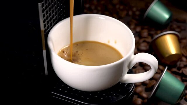 Automatic coffee machine with coffee capsules or pods pouring espresso drink. Making coffee in a coffee machine. Brewing a coffee