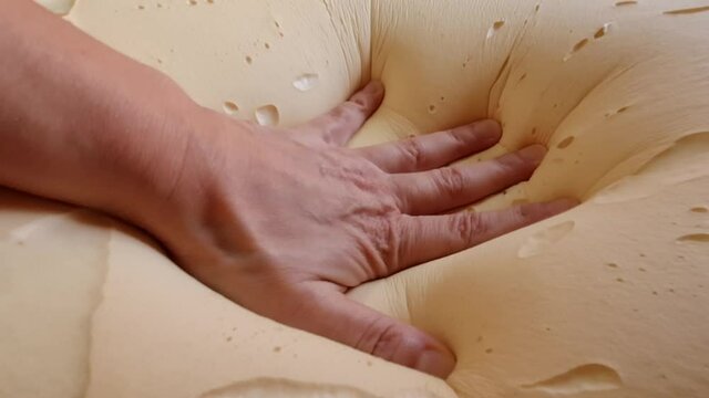 A closeup of a person testing a memory foam pillow and pushing it down shot in HD