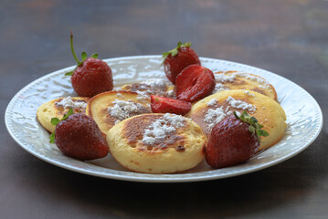 Delicious pancakes with berries, honey or grape syrup. Homemade pancakes and sweet syrup on a white plate isolated.