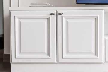 Front view of white wooden chest of drawers with metal long handles