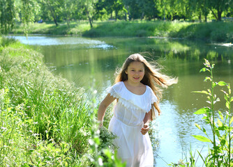 Girl in beautiful wreath on summer meadow near the river. Feast of Ivan Kupala.Midsummer. Earth...