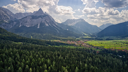 View of high rocky mountains and green dense forests on a sunny day