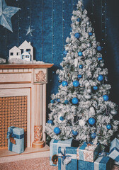 Christmas tree with blue and white toys and gift boxes in the interior