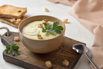 cream of cheese and potatoes soup with bread and herbs