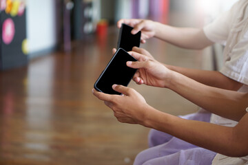 Teenagers' hands  holding mobile smartphone. Blank screen for adding text.  Concept : spending time to playing games online . Favorite free time activity. Using smartphone.     