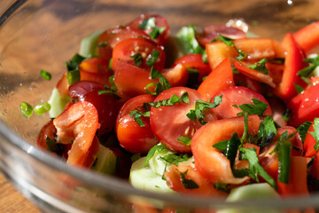 vegetable salad in a glass bowl on a wooden table.