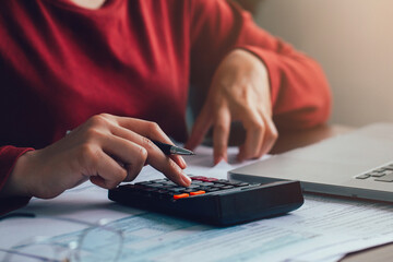 Close up businesswoman using calculator for doing math finance on wooden desk in the office. account, taxes, home budget concept - obrazy, fototapety, plakaty