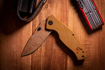 folding knife on a wooden surface with accessories 