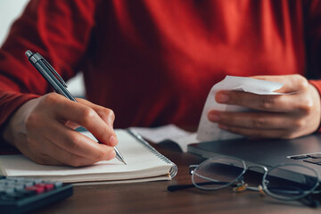 Women calculate domestic bills at home. Young women checking balance costs and note the expenses....