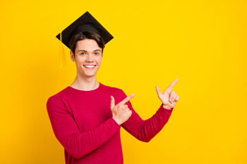 Photo of sweet attractive gentleman wear red pullover academic headwear pointing fingers empty space isolated yellow color background